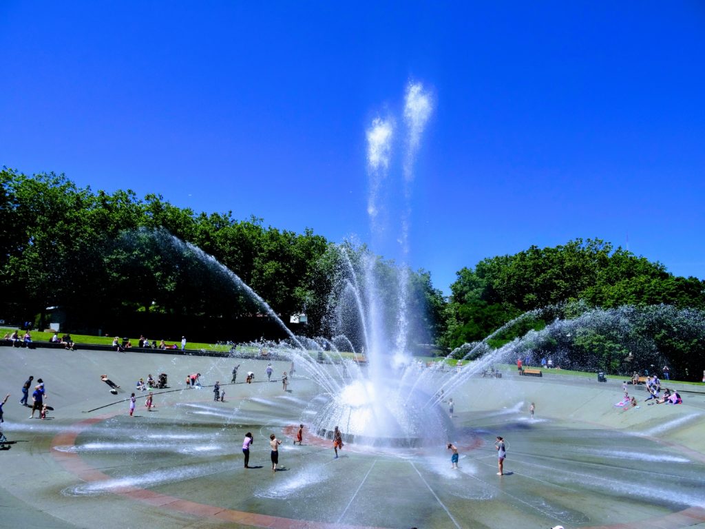 Photo of youth playing and cooling off at the Seattle Center Internationa Fountain