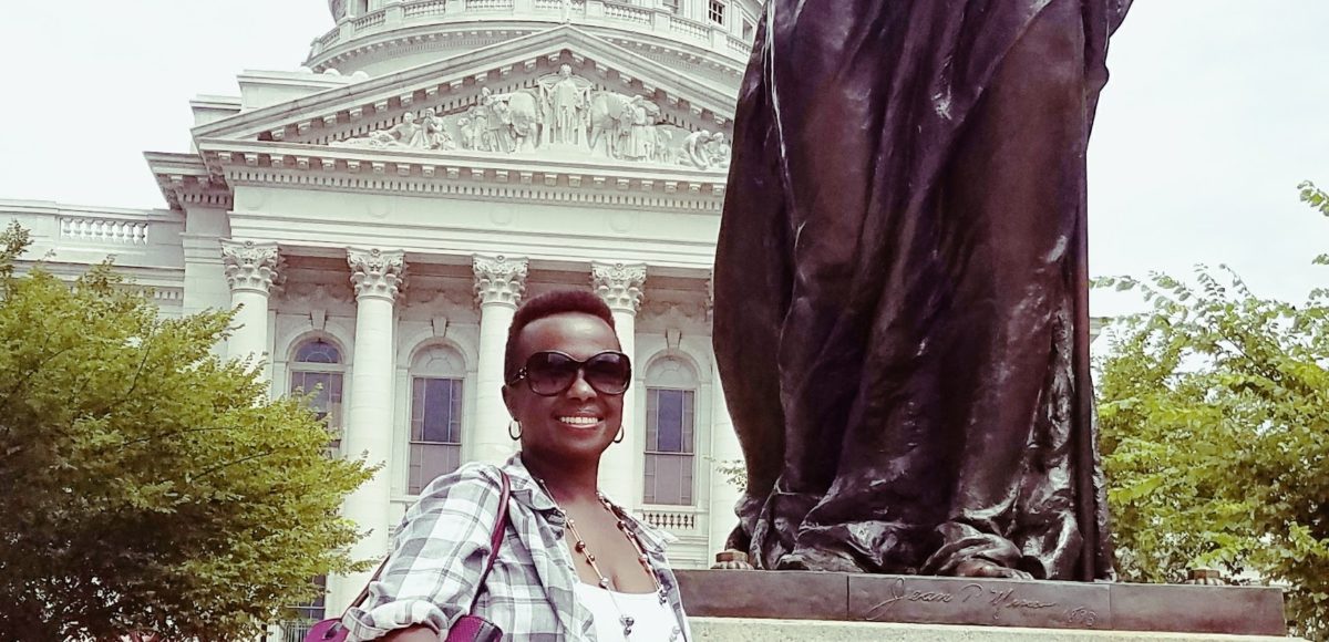 Carol Lwali standing by a statue madison WI capitol